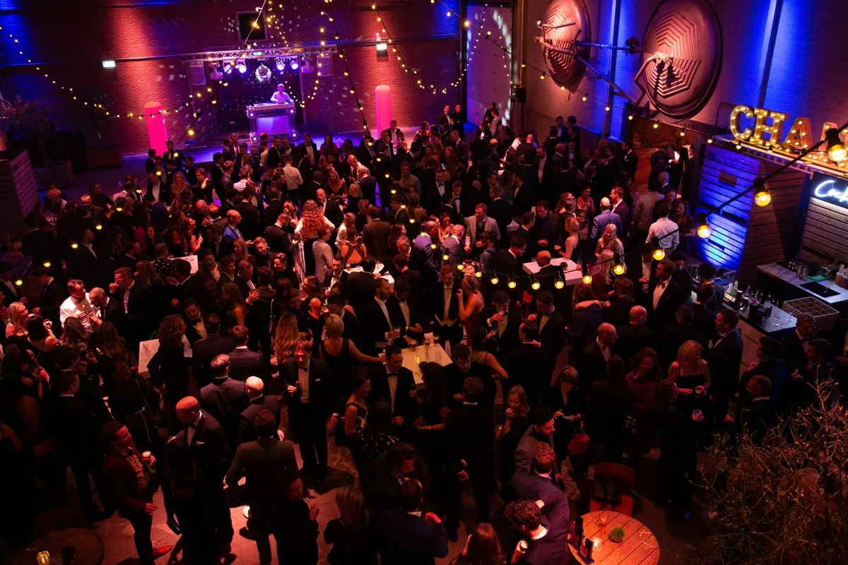 Grote zaal met mensen die feesten
