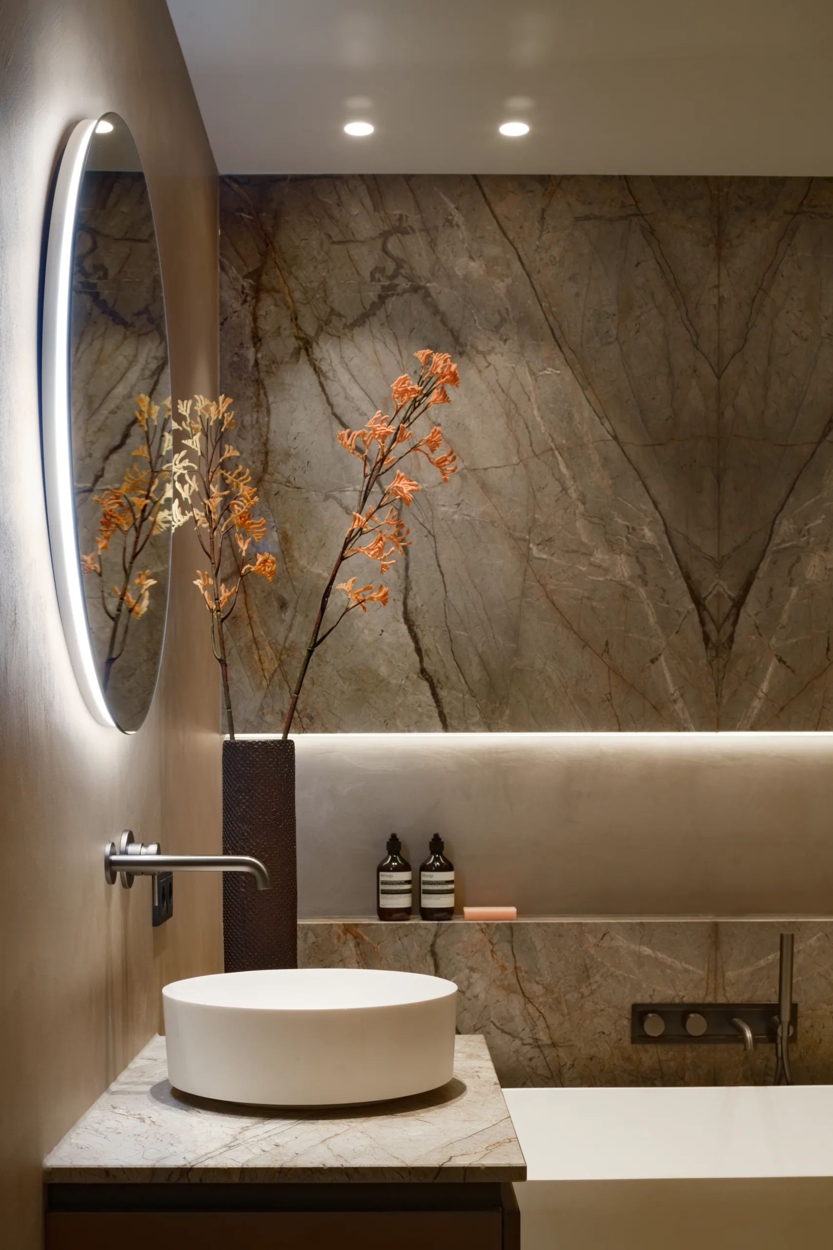 Badkamer met wasbak, bad en mooie stenen look