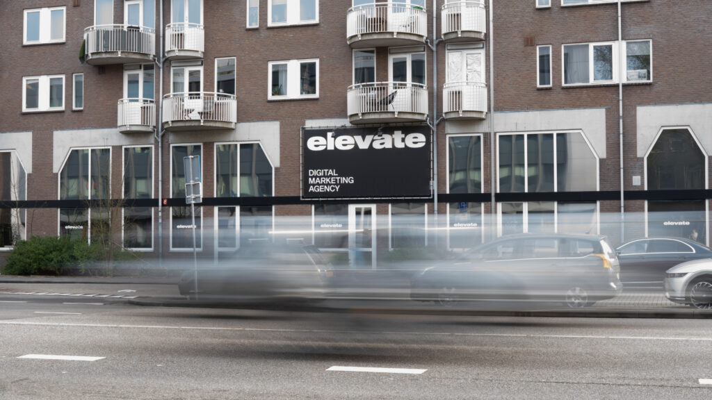 Het kantoorpand van Elevate Digital met auto's die langsrijden