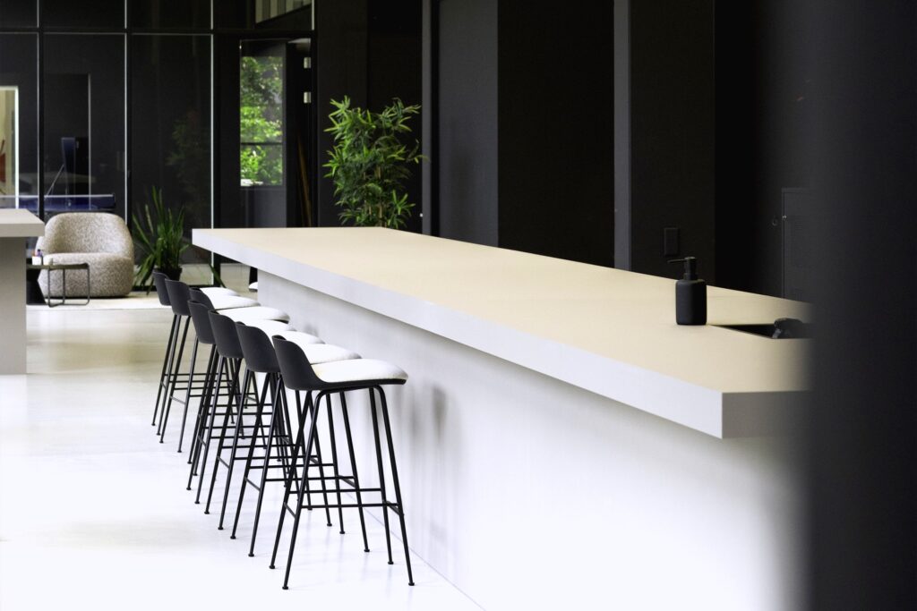 Lange bar met stoelen en planten op de achtergrond