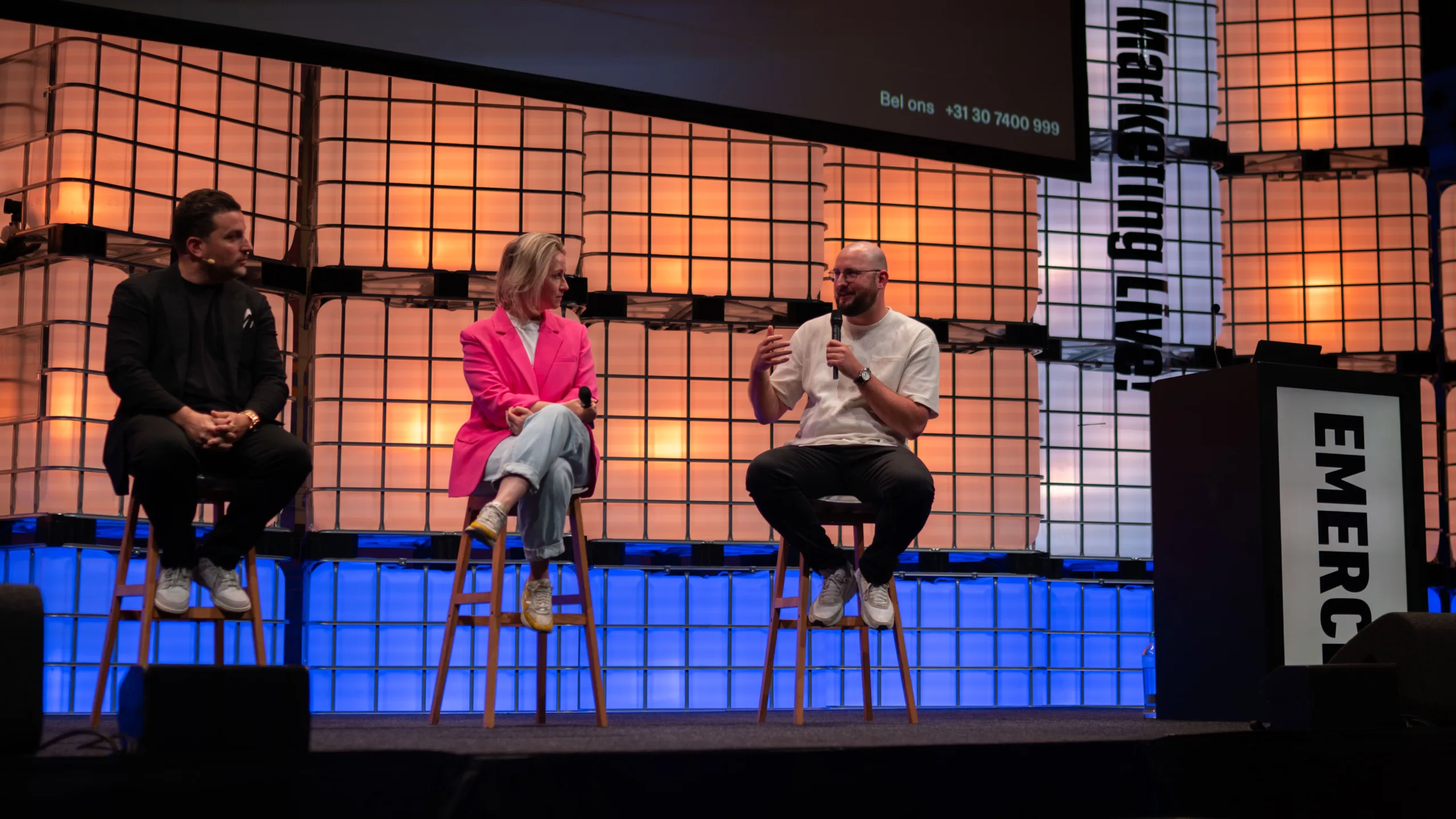 Drie mensen spreken op een podium over marketing