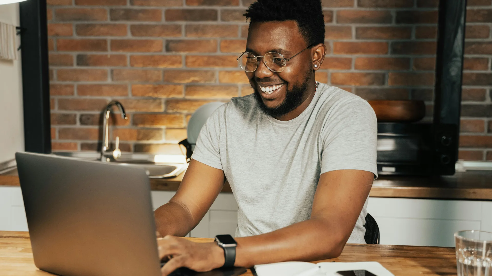 Man in zijn keuken achter zijn laptop te werken