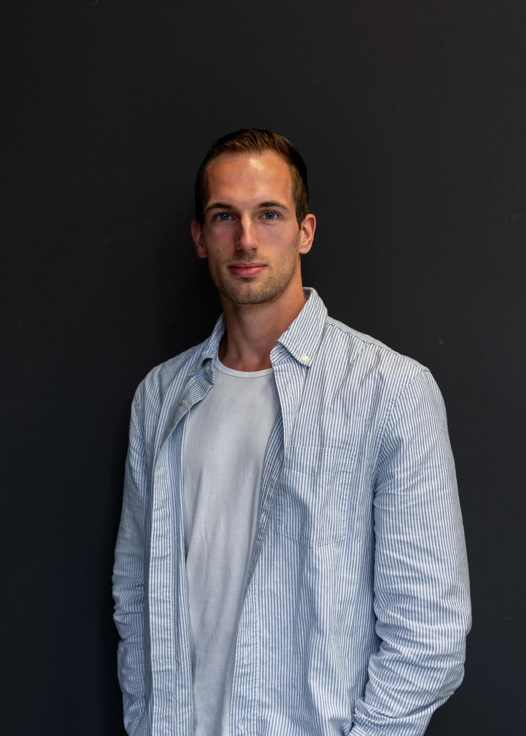 Collega poseert voor foto met donkere achtergrond
