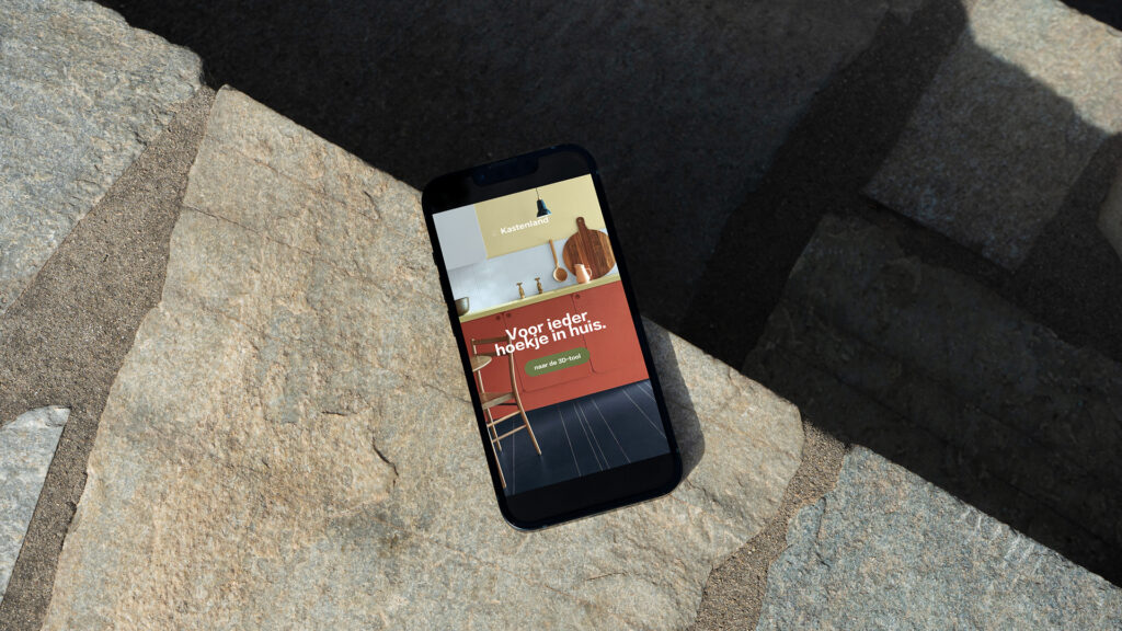 Klant van Elevate Digital: Kastenland reclame op telefoon. Telefoon ligt op stenen