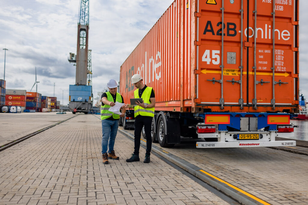 Twee mannen overleggen naast een een vrachtwagen op een werkplaats