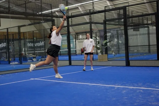 Twee mensen die padellen op een padel baan