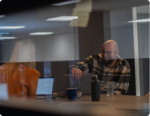 twee mensen in een meeting te zien door het glas van een vergaderruimte